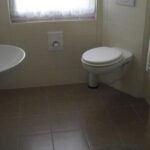 Badezimmer mit bodenebener Dusche und Eck-WC